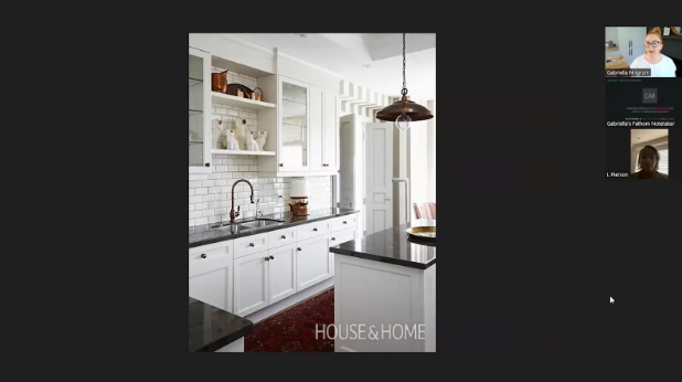 Bright kitchen with white cabinets, subway tile backsplash, and black countertops. Pendant light hangs above island, creating a modern, clean look.